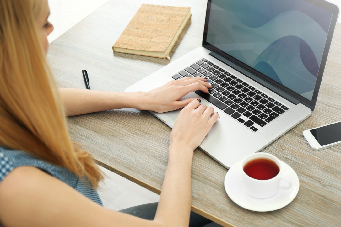 Woman working with laptop on wooden table